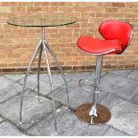 A GLASS TOPPED COCKTAIL TABLE on chrome steel support, 69cm diameter 104cm high, together with a