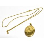 A 9CT GOLD OVAL LOCKET With a marked 375 fine link chain, the oval locket with foliate pattern to