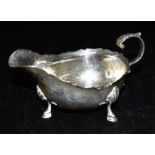 AN EDWARDIAN SILVER SAUCE BOAT Hallmarked for Birmingham 1902, Maker WH standing on three hooved