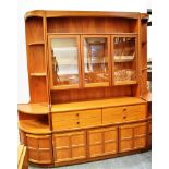 A G-PLAN STYLE 1970S TEAK LOUNGE UNIT the centre with glazed upper section above four drawers and