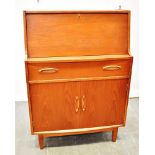 A G-PLAN STYLE TEAK BUREAU the fall front opening to fitted interior, above single drawer and