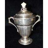 A LIDDED TWO HANDLED SILVER TROPHY with resin knob to lid the trophy inscribed with details for
