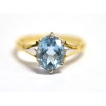 AN 18CT GOLD AQUAMARINE RING the oval facetted aquamarine on openwork shoulders, the shank marked