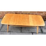 AN ERCOL MODEL 459 BLOND ELM AND BEECH COFFEE TABLE of rounded rectangular form, with spindle rack
