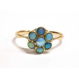 A 9CT GOLD, OPAL FLOWER HEAD RING faded markings to shank, flower head size approx. 9mm in diameter,