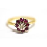 A DIAMOND AND RUBY FLOWER HEAD RING The flower head measuring approx. 8mm in diameter on a yellow