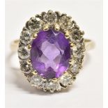 AN 18CT GOLD AMETHYST AND DIAMOND CLUSTER RING the oval facetted amethyst measuring approx. 0.9cm by