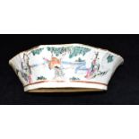 A CHINESE CRESCENT SHAPED DISH decorated to one side with figures in a garden, the other side with