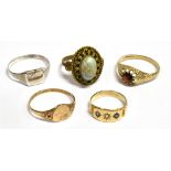 A COLLECTION OF FIVE RINGS comprising an unmarked small yellow metal gypsy set ring, ring size K,