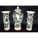 A GARNITURE OF THREE ORIENTAL VASES decorated with dragons on a green ground, comprising baluster