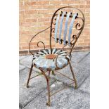 A WROUGHT IRON FRAMED ARMCHAIR with shaped copper strips forming a sprung circular seat and back,