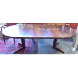 A 1970S EXTENDING CIRCULAR DINING TABLE WITH TWO ADDITIONAL LEAVES on cruciform base, apparently