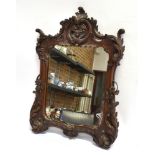 A WALL MIRROR IN ORNATELY CARVED ROSEWOOD FRAME 52cm x 37cm overall Condition Report : nice quality,