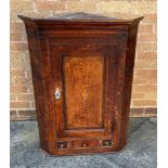 A GEORGE III OAK HANGING CORNER CABINET the door with marquetry inlaid conch motif, above single