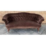 AN EDWARDIAN BUTTON UPHOLSTERED SOFA with serpentine front seat, on carved walnut supports, 190cm