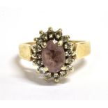 AN ALMANDINE, DIAMOND AND GOLD CLUSTER RING The oval Almandine measuring 0.7cm x 0.5cm and
