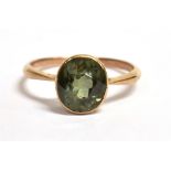 A GREEN SPINEL RING The oval faceted spinel measuring 0.8cm by 0.6cm on a yellow shank stamped