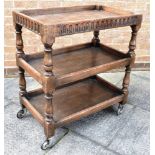 A THREE TIER OAK TEA TROLLEY the top gallery with carved decoration, 46cm x 77cm, 85cm high