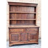 AN OAK WELSH DRESSER the rack with boarded back and two shelves, the base with two drawers over