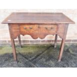 AN OAK SIDE TABLE with mahogant crossbanding, single frieze drawer and shaped apron, 87cm wide