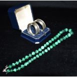 A MALACHITE NECKLACE TOGETHER WITH A CASED PAIR OF SILVER NAPKIN RINGS The necklace comprising of