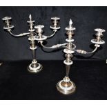 A PAIR OF SILVER PLATED ON COPPER THREE LIGHT CANDLEABRAS With ornately decorated twin scrolled arms