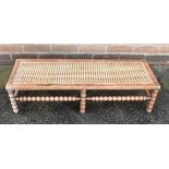 A FOOTSTOOL WITH CANED TOP, on beech bobbin turn base, 29cm x 92cm, 23cm high Condition Report :