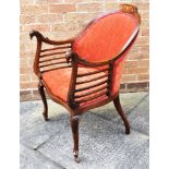 AN EDWARDIAN CARVED MAHOGANY FRAMED ARMCHAIR with marquetry inlaid decoration, the arms carved as