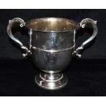 A TWO HANDLED SILVER TROPHY The trophy of plain form with curved handles and no inscriptions or