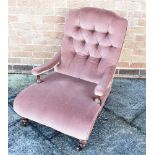 A VICTORIAN HOWARD STYLE ARMCHAIR with button upholstered back, arms and low deep seat on fluted