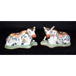 A PAIR OF POLYCHROME ENAMELLED FRENCH FAIENCE FIGURES OF SEATED COWS 17cm long Condition Report :