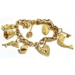 A VINTAGE CHARM BRACELET The bracelet comprising of a stamped 375 curb link bracelet, a 9.375