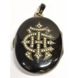 A LARGE MID VICTORIAN SEED PEARL AND ENAMEL MEMORIAL LOCKET the black enamelled locket with seed