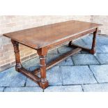 AN OAK REFECTORY DINING TABLE the four plank top with cleated ends, on turned supports with H-