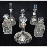SIX DECANTERS AND STOPPERS each with hallmarked silver wine labels for Sherry, Gin, Whiskey, Brandy,