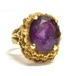 A VINTAGE 9CT GOLD AMETHYST COCKTAIL RING the oval facetted amethyst measuring 1.5cm by 1.1cm, the