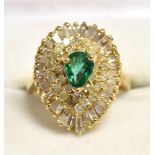 AN EMERALD AND DIAMOND 18CT GOLD CLUSTER RING The pear cut emerald set in a Ballerina mount of 29