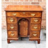 A QUEEN ANNE STYLE WALNUT KNEEHOLE DESK the quarter veneered top with featherbanding and re-