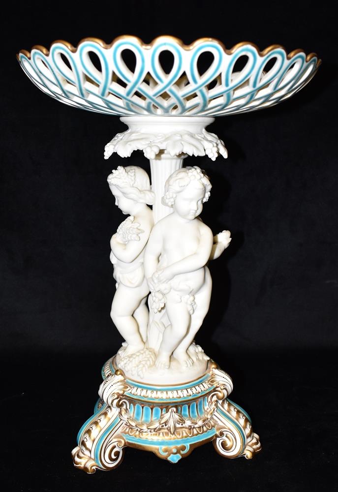 A LARGE VICTORIAN FIGURAL COMPORTE the pierced basket 29cm diameter, the support with three cherubs,