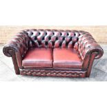 A TWO SEATER DARK RED CHESTERFIELD SOFA H 68cm x W 156cm x D 88cm