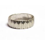 A TEXTURED BAND RING WITH FADED MARKINGS ASSESED AS PLATINUM Ring size P, Band width 0.6cm, weight