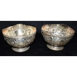 A MATCHED PAIR OF SHEFFIELD SILVER BOWLS the bowls heavily embossed with flowers, scrolls and a