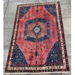 A RED GROUND AFSHAR RUG with central medallion, 243cm x 163cm
