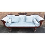 A REGENCY STYLE CARVED MAHOGANY FRAMED SOFA with scroll arms, loose squab and pair of bolster
