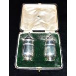 A CASED PAIR OF SILVER MAPPIN & WEBB CONDIMENTS hallmarked for Birmingham 1915, weight to include