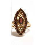 A MARKED 9CT GOLD GARNET NAVETTE RING The Navette measuring 2.2cm by 1.1cm at widest point, the