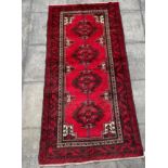 A RED GROUND TURKOMAN RUG with four medallions, 255cm x 124cm
