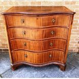 A SERPENTINE MAHOGANY AND VENERRED CHEST OF FOUR LONG DRAWERS and flanked by canted sides H 119cm