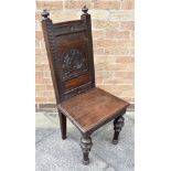 A CARVED OAK HALL CHAIR