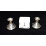 A PAIR OF EDWARDIAN WEIGHTED SILVER DWARF CANDLESTICKS Together with a small silver standing '